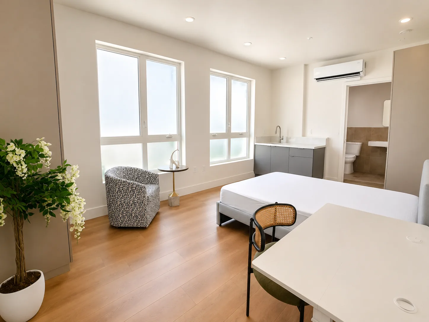 Actual Unit 202 standard private bedroom with desk, seating, kitchenette, and bathroom access
